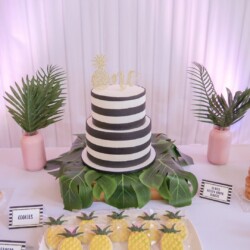 A cake and pineapple decorations on the table.
