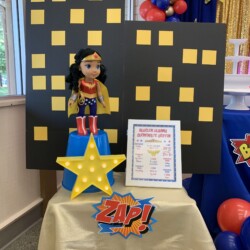 A table with a star and a wonder woman doll on it.