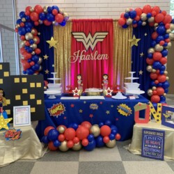 A table with balloons and other decorations on it.