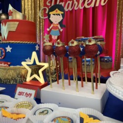 A table with cake pops and other treats on it.