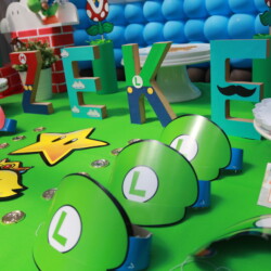 A table with green balloons and some paper mario hats