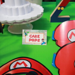 A table with cake pops and mario characters.