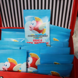 A pile of packets of cereal in front of a red and black striped background.