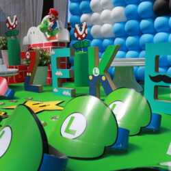 A table with green balloons and letters that say " luigi ".