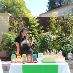 A woman standing next to a table with some food.