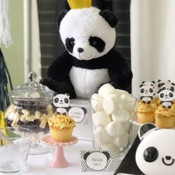 A table with panda bear cupcakes and marshmallows.