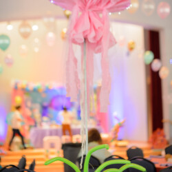 A pink flower with a bow on it's head.
