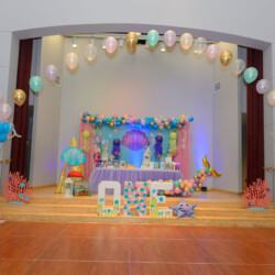 A stage with balloons and decorations in the middle of it.