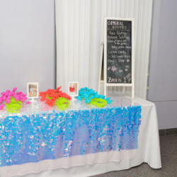 A table with a white cloth and some blue sequins