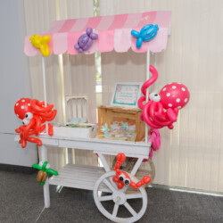 A white cart with balloons and other decorations.