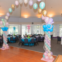 A room with balloons and tables in it