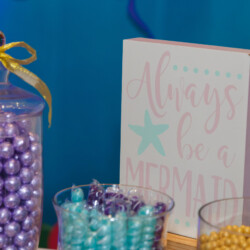 A table with candy and a sign that says " always be a mermaid ".