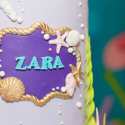 A close up of the name of zara on top of a cake.
