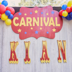 A carnival sign with balloons and the name kian