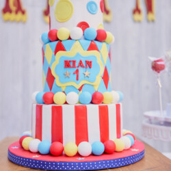 A circus themed birthday cake with the name kian on it.