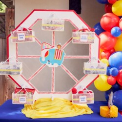 A ferris wheel with balloons and candles on the table