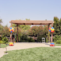 A wooden structure with balloons in the middle of it.