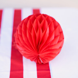 A red paper ball sitting on top of a table.