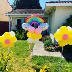 A rainbow balloon is in the shape of a flower.