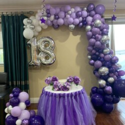 A table with a cake and balloons on it