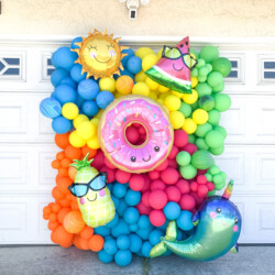 A photo of balloons and decorations in front of a garage door.