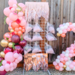 A display of balloons and a tower with pink decorations.