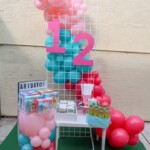 A table with balloons and other decorations on it.
