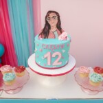 A cake with a girl on top of it